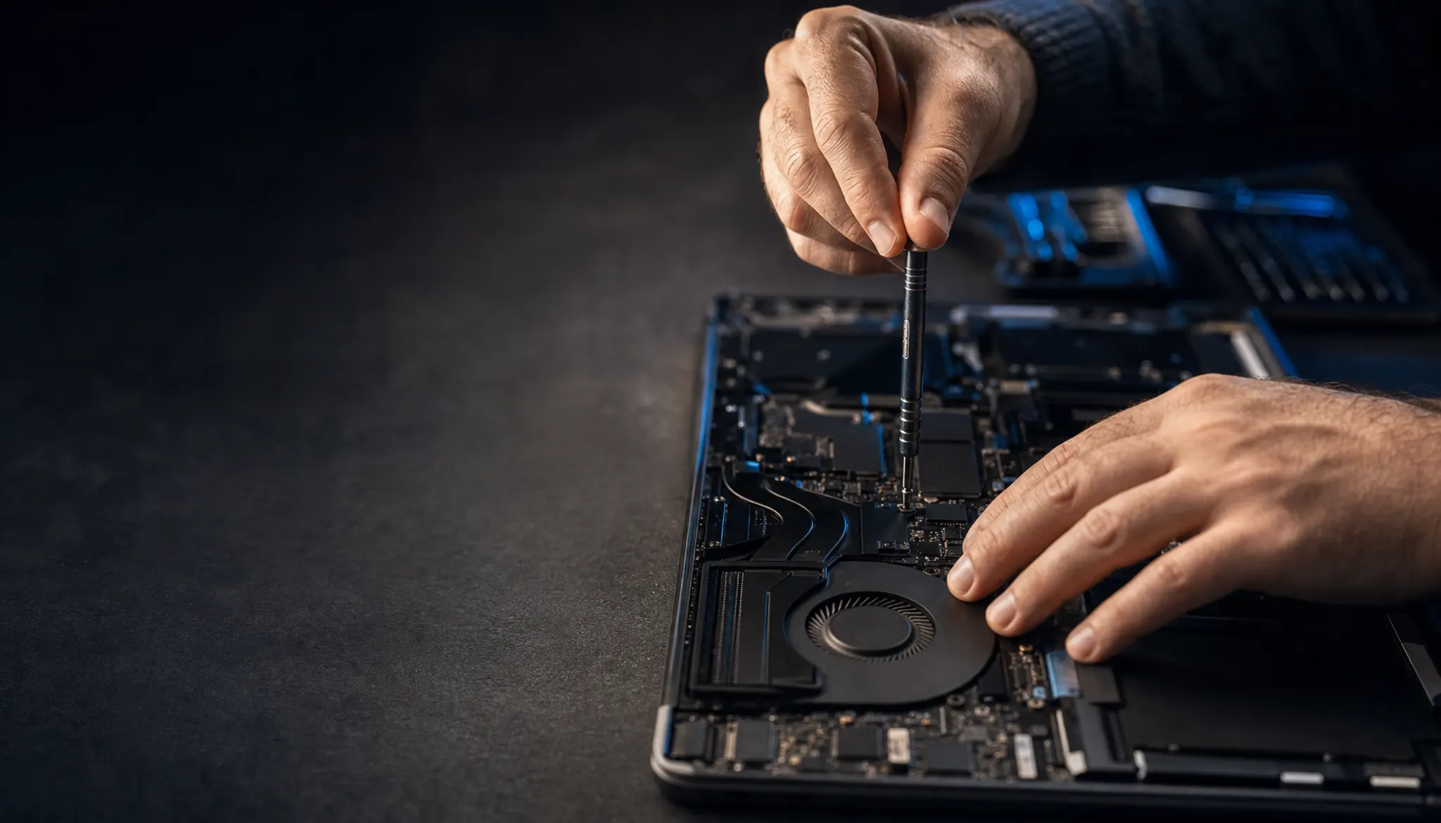 Technicus die met een precisieschroevendraaier aan de koeling van een geopende laptop werkt